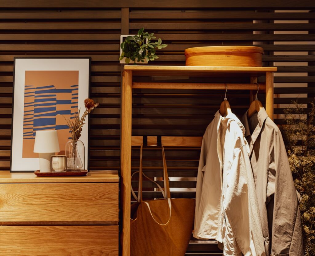 Wooden dresser with artwork and hanging coats