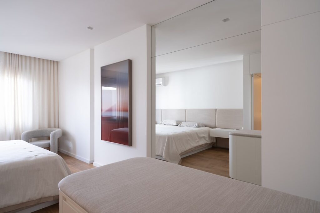 Modern bedroom with two beds and large mirror