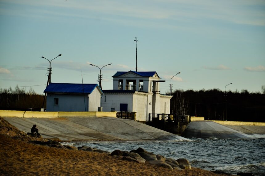 A building stands beside flowing water.