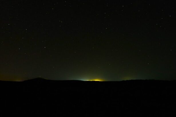 Stars shine over a distant city at night.