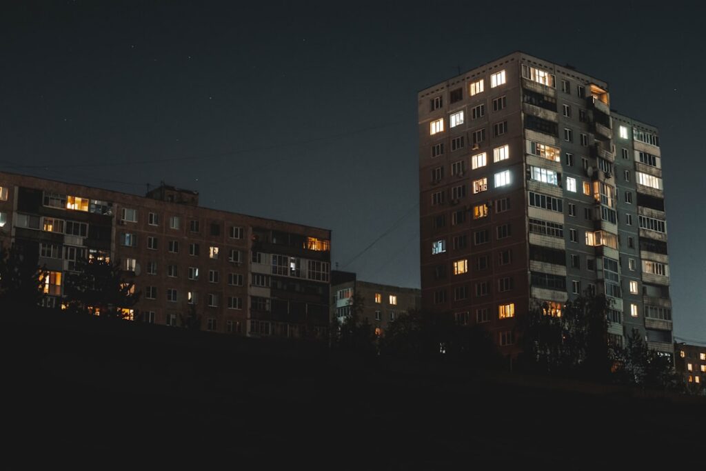 Apartment buildings glowing with lights at night.