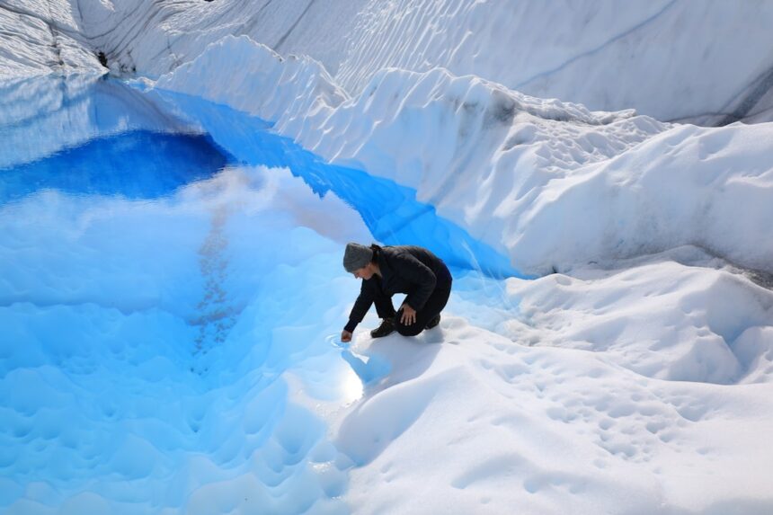 A man standing in the middle of a snow covered mountain