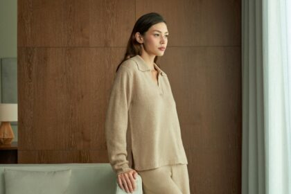 Woman in beige loungewear looking out window