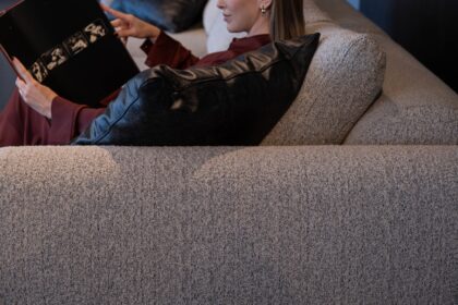 Woman reading a book while relaxing on a couch.