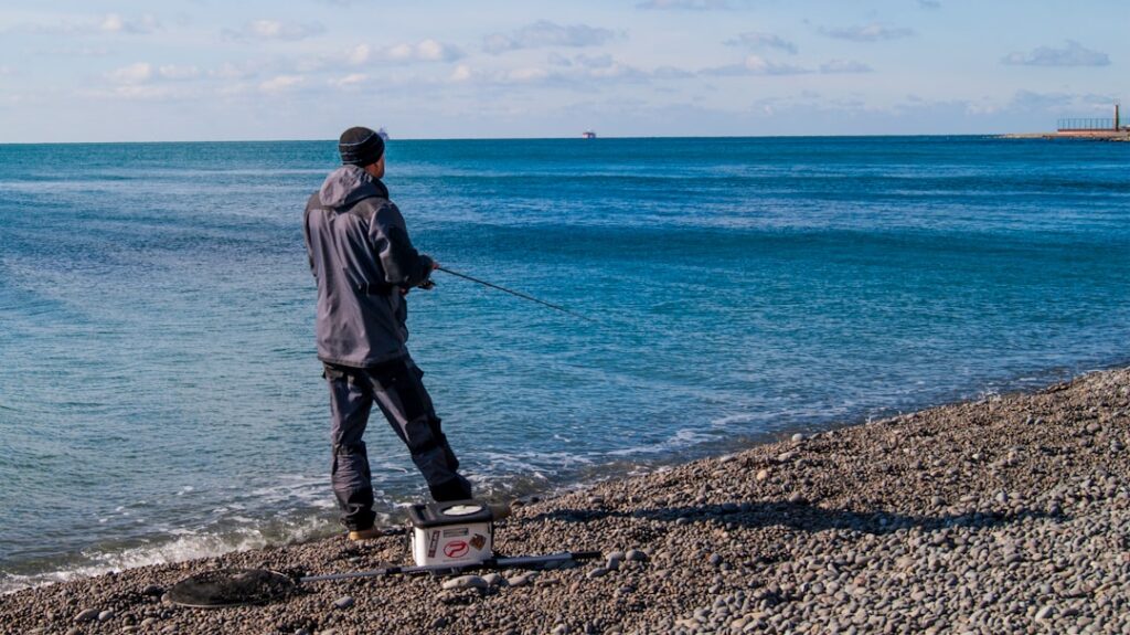 a man standing on a beach next to the ocean
