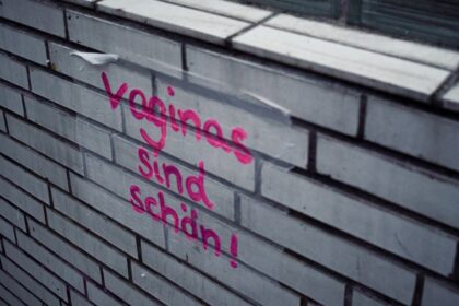A brick wall with graffiti written on it