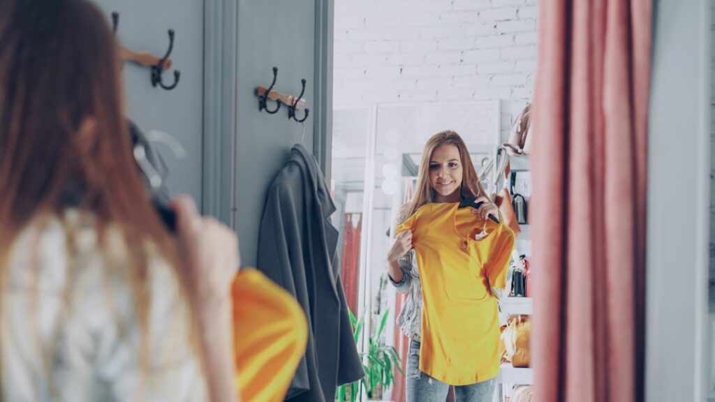Woman tries on clothes in a dressing room.