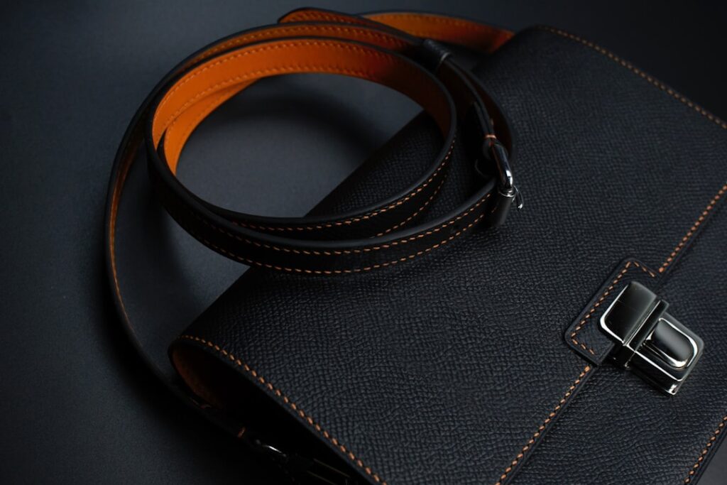a black and orange handbag with a black strap