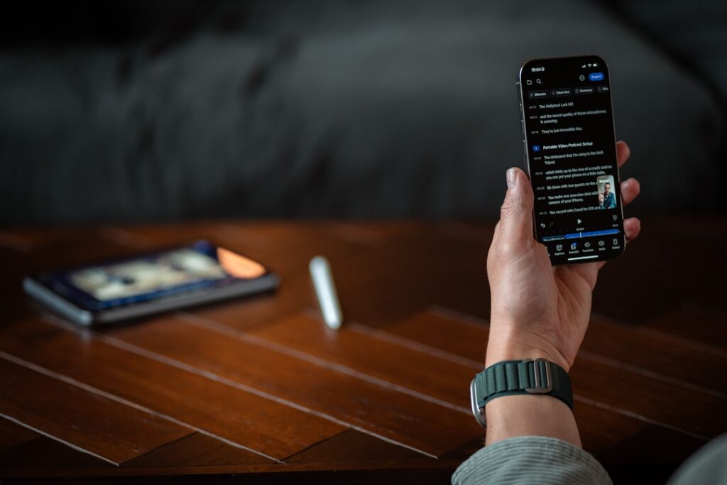 Person holding a smartphone with a dark screen.