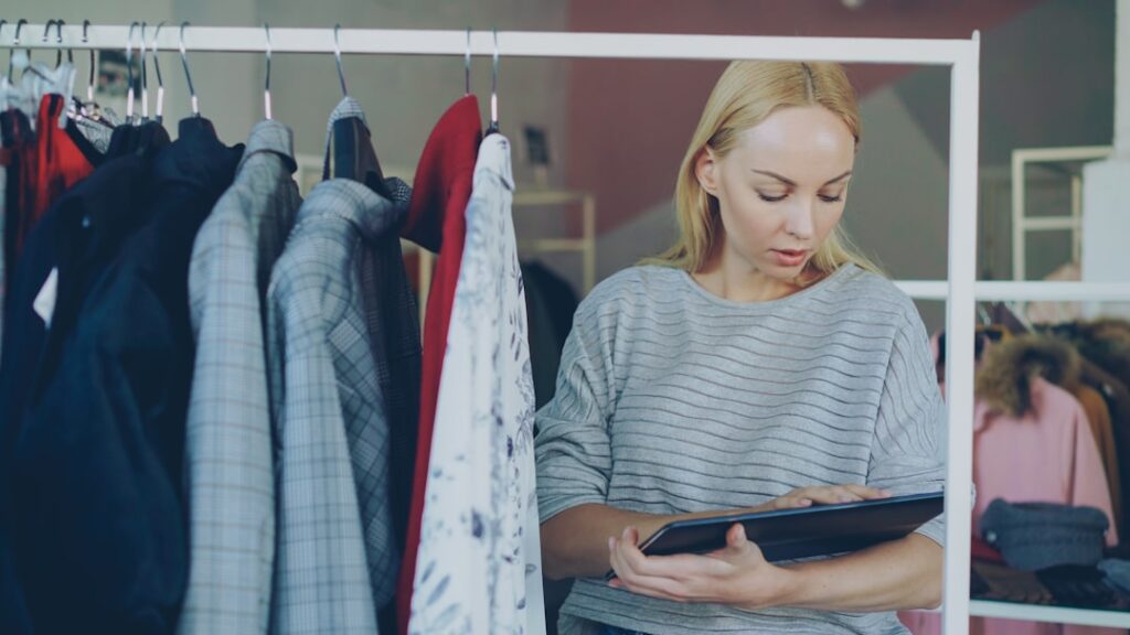 Woman reviews inventory in a clothing store.
