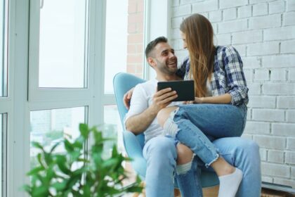 Couple looking at tablet together in armchair