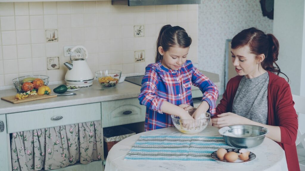 Mother and daughter are baking together in the kitchen.