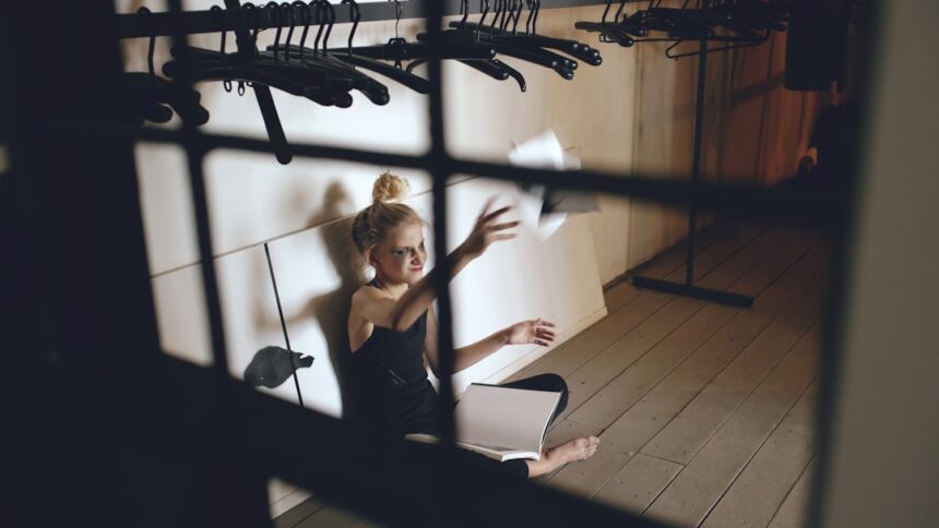 Young woman sitting on floor, throwing papers