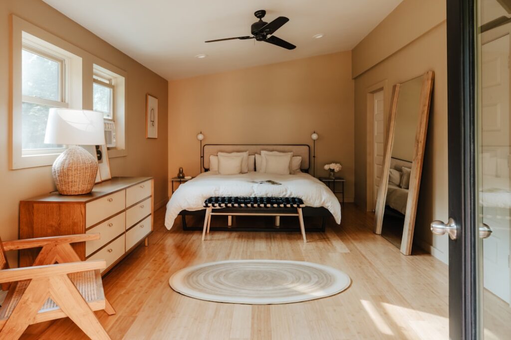 A bedroom with a bed, dresser, and a window