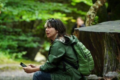 Woman with backpack sitting in a forest
