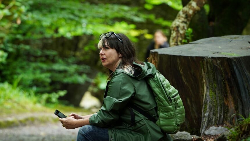 Woman with backpack sitting in a forest