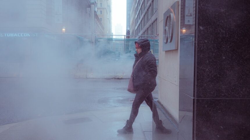 Person walking through steam on a city street.