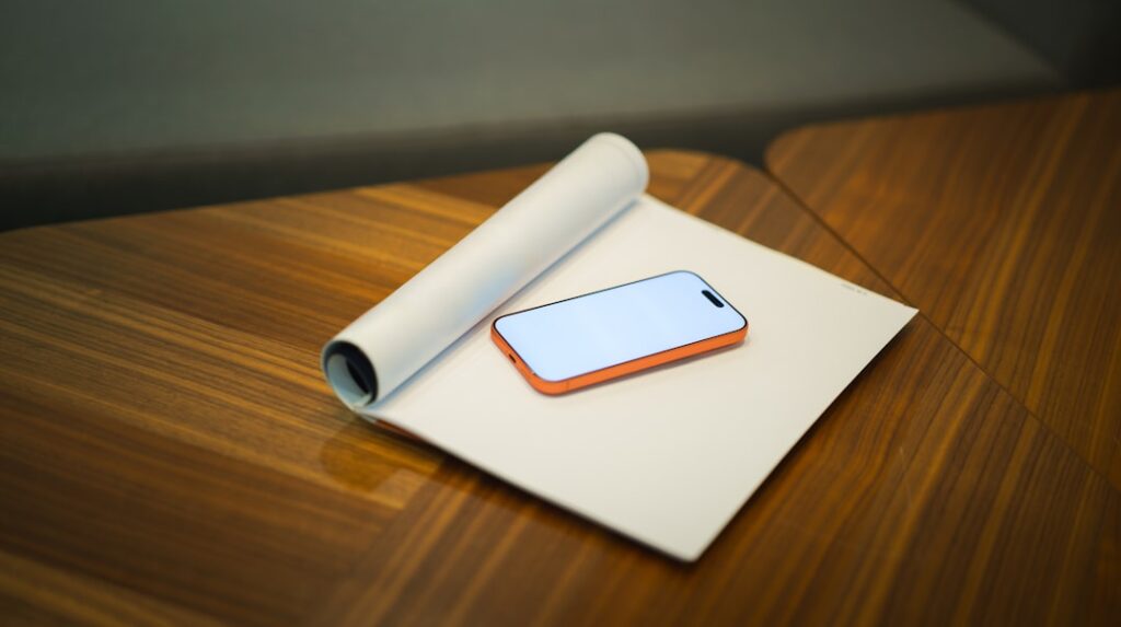 Smartphone on a rolled paper on a wooden desk