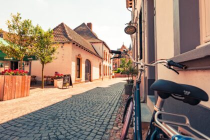 Bicycle parked on a cobblestone street in a european town.
