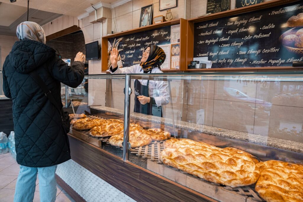 Customer ordering bread from baker in a shop