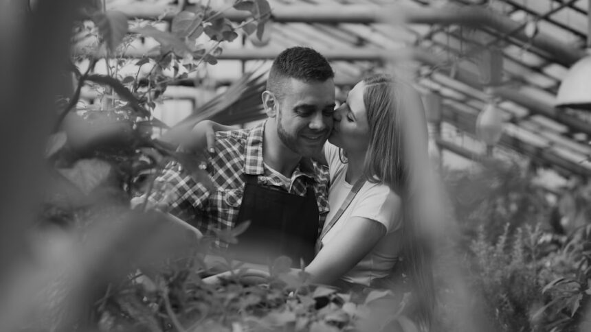 Couple sharing a tender moment in a greenhouse.