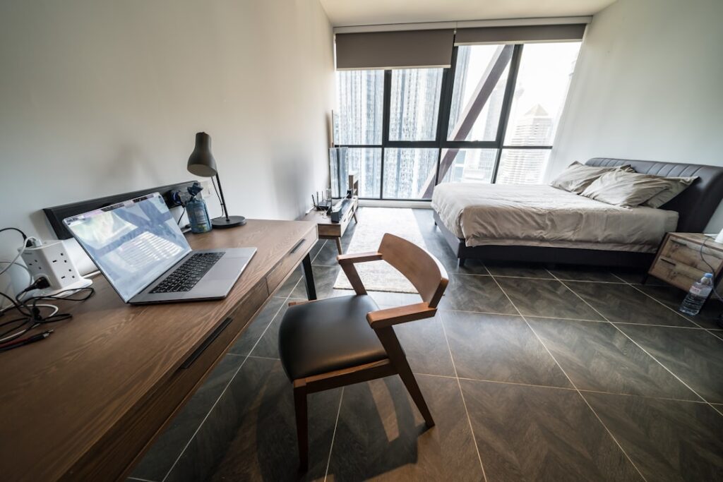 Modern bedroom with a desk and city view.