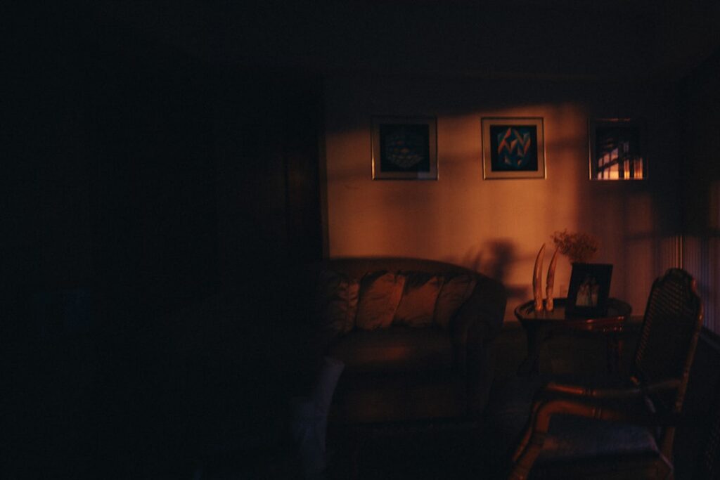 Dimly lit living room with framed art on wall.