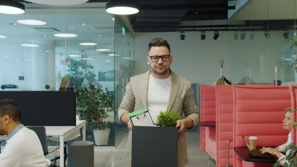 Man carrying box of belongings in office