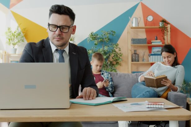 Man working on laptop while family relaxes in background