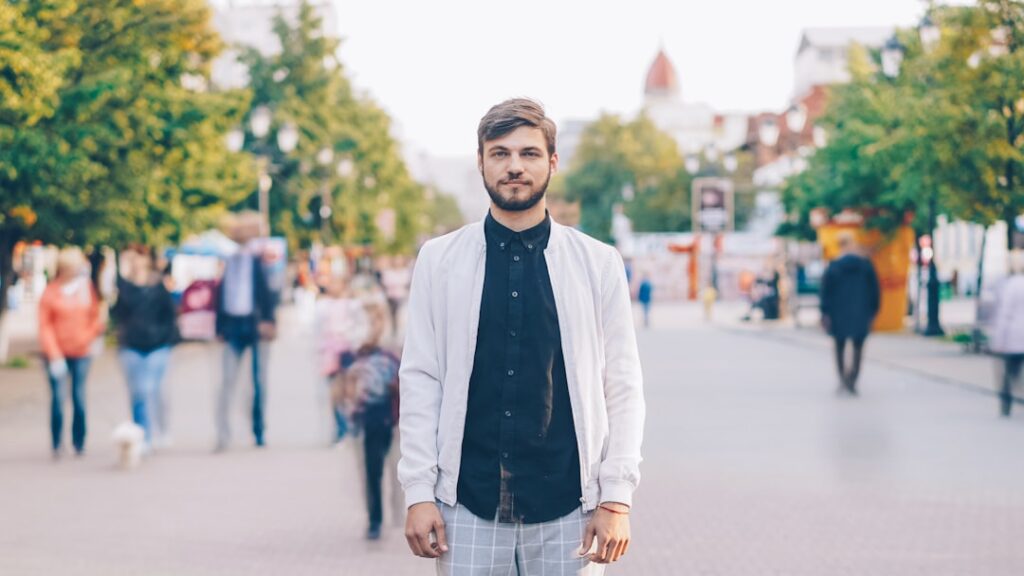 A man stands on a busy city street.