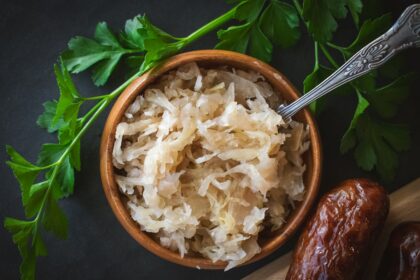 a wooden bowl filled with rice next to a spoon