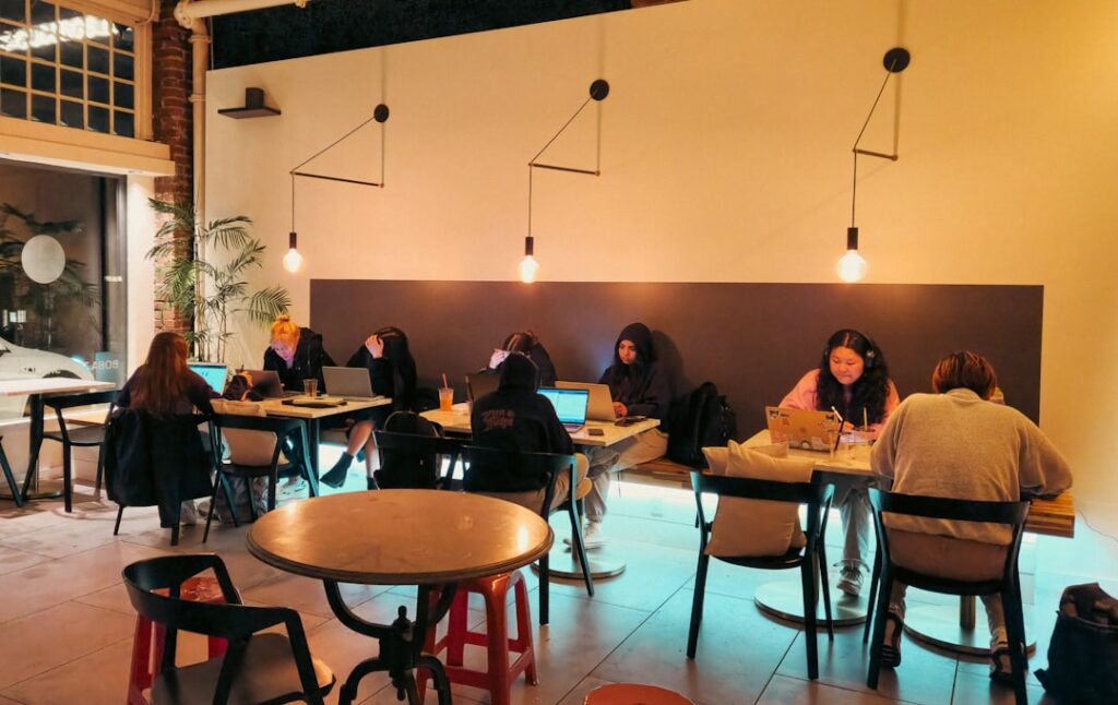 People are working on laptops in a cafe.