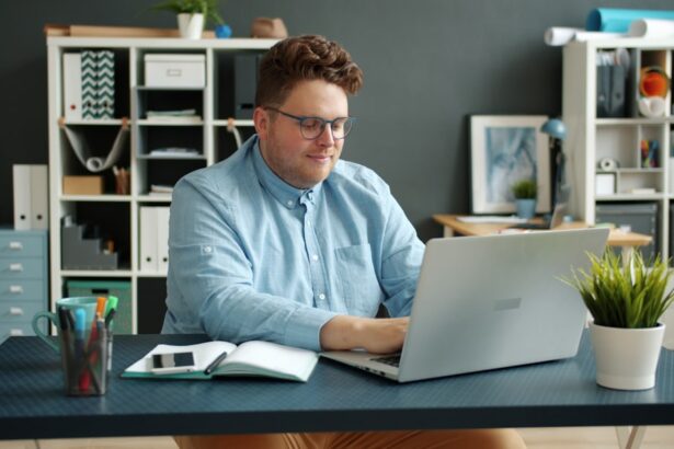 Man working on laptop at desk in office.