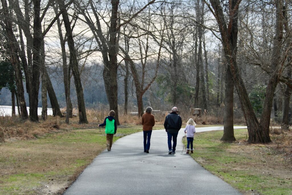 a group of people walking down a path in a park
