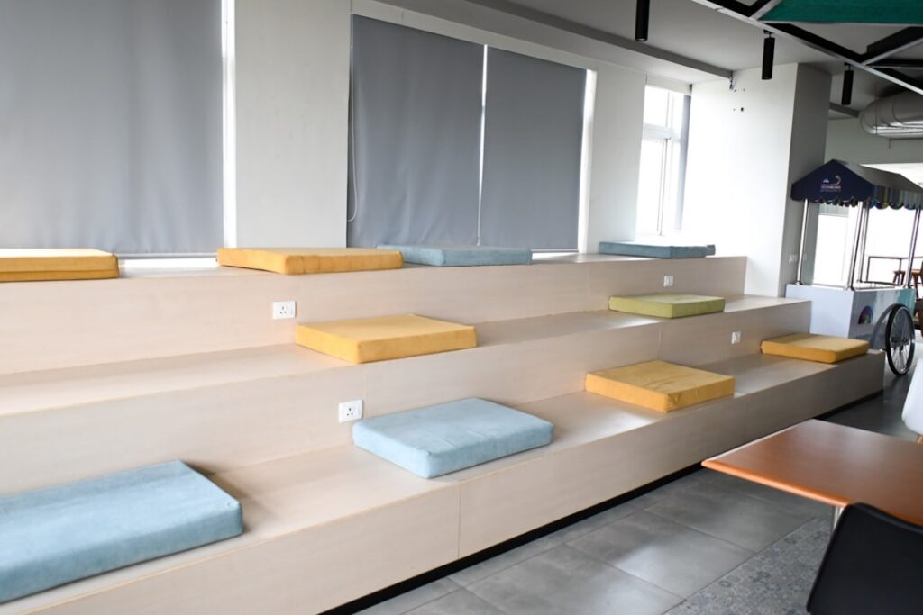 Tiered seating area with cushions in a modern office space.