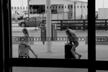 grayscale photography of two girls playing on stroillers