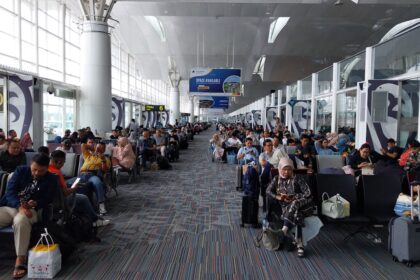 A large group of people waiting for their luggage