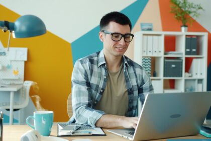 Man working on a laptop in a colorful office.