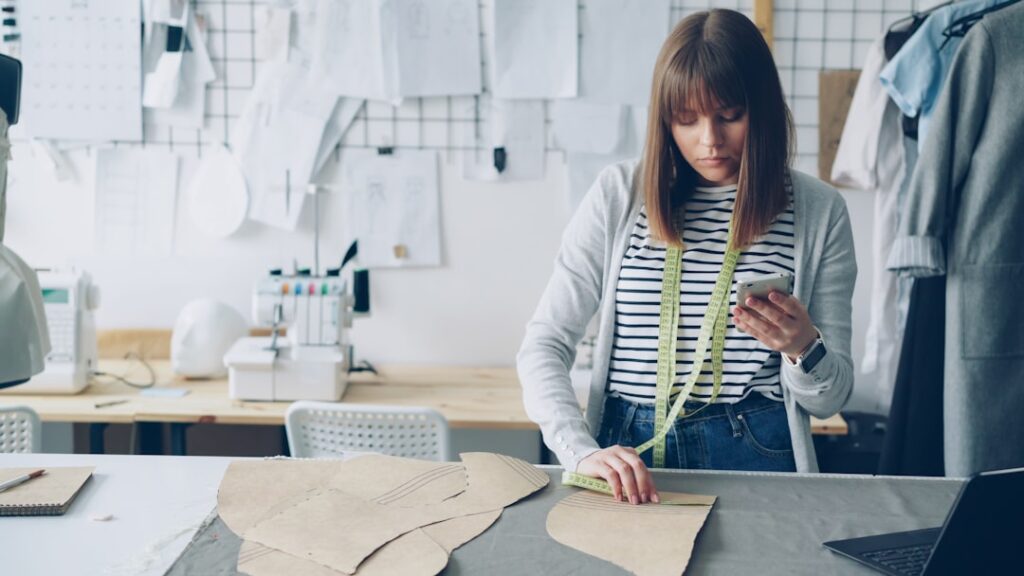 A seamstress uses her phone in her workshop.