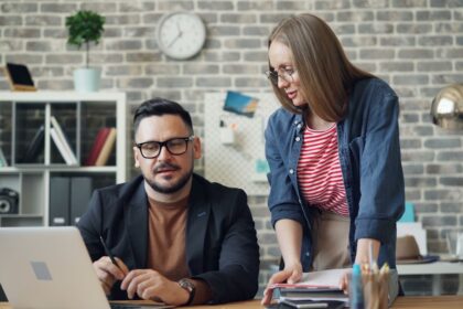 a man and a woman looking at a laptop