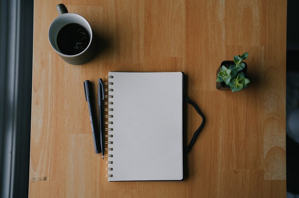 Notebook and coffee on a wooden table.