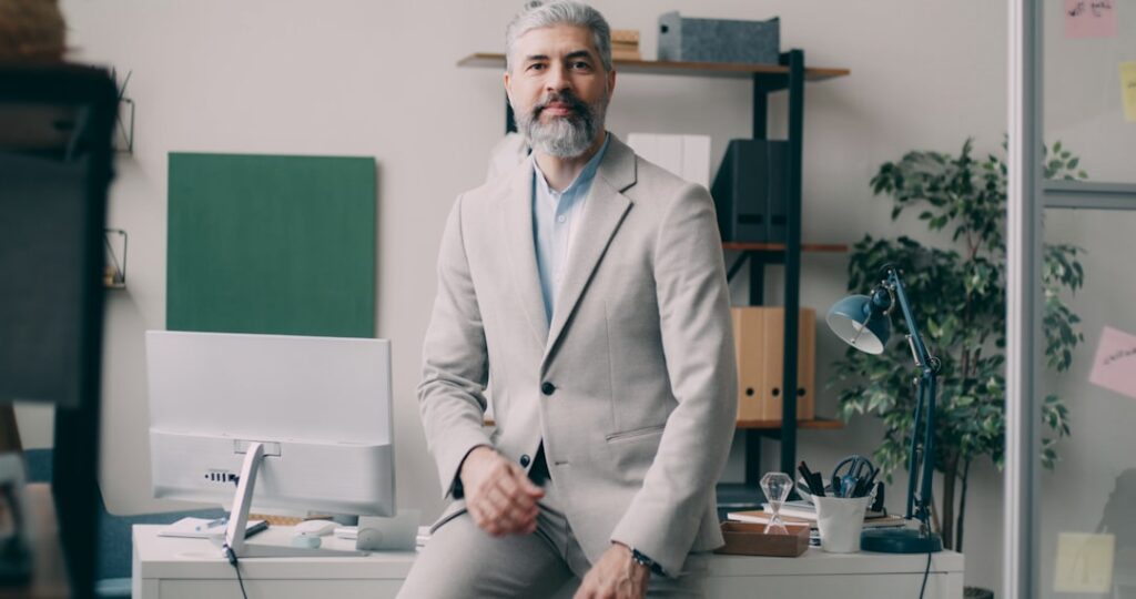 A man sitting on a desk in an office