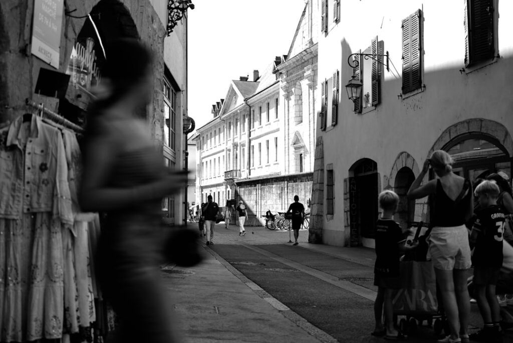 People walking down a sunlit european street.