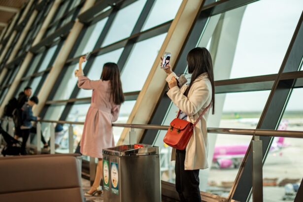 Two women taking selfies by airport window