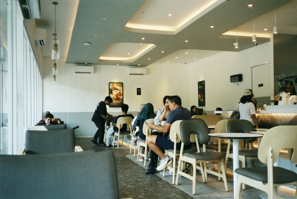 People enjoying coffee at a modern cafe interior.
