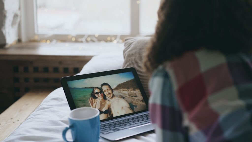 Woman video calls with couple on beach