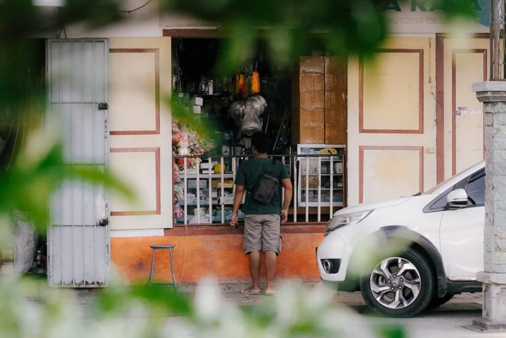 a man standing in front of a small store