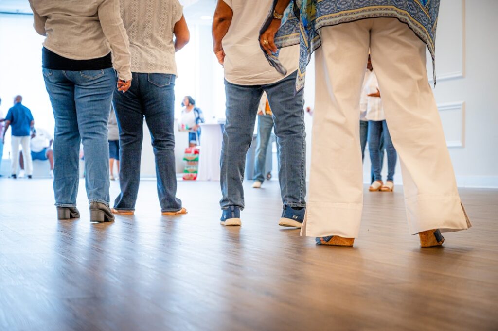 People standing in a room with wooden floor