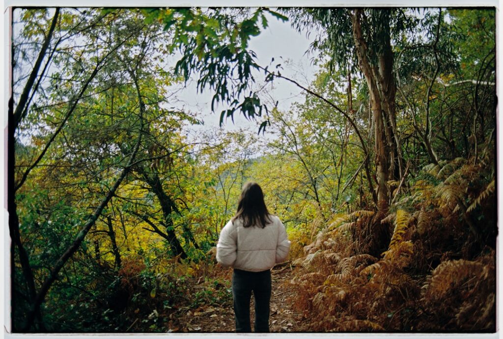 Person walking on a forest path with trees.