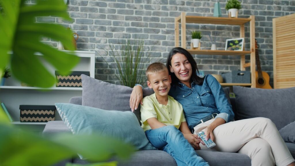 Mother and son smiling on a couch